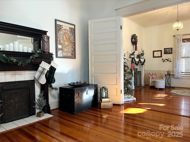 living room with a tiled fireplace and hardwood / wood-style floors