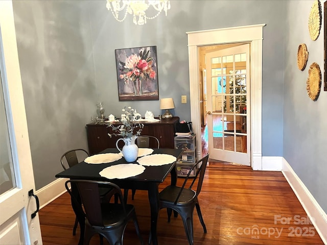 dining area with an inviting chandelier and wood-type flooring