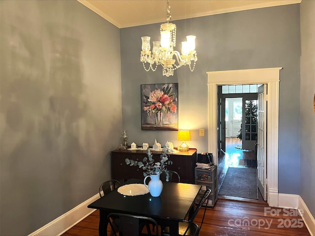 dining area featuring dark hardwood / wood-style flooring, crown molding, and a notable chandelier