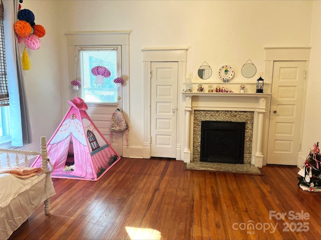 rec room with dark hardwood / wood-style floors and a premium fireplace