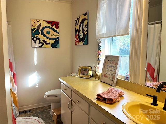 bathroom featuring toilet, vanity, and tile patterned flooring