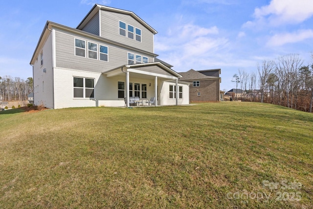 rear view of property featuring brick siding and a yard