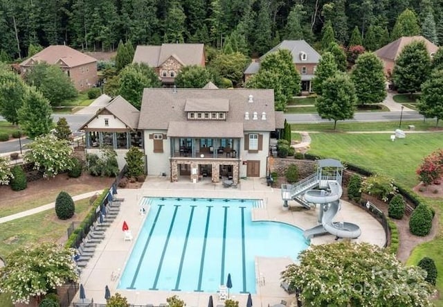 exterior space with a lawn, a patio area, fence, and a community pool