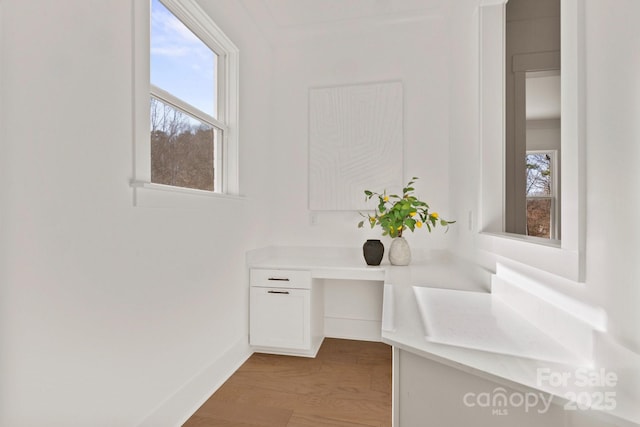 interior space featuring plenty of natural light, wood finished floors, and baseboards