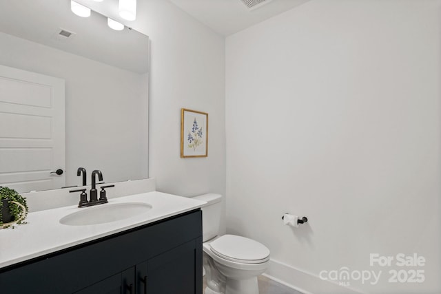 half bath with toilet, visible vents, and vanity