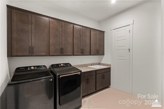 laundry area with independent washer and dryer, cabinet space, and a sink