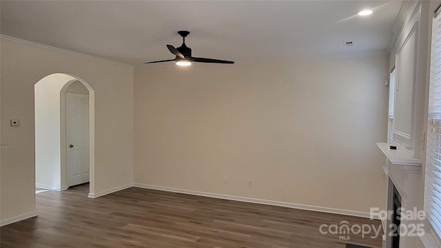 empty room with ceiling fan, dark hardwood / wood-style floors, and crown molding