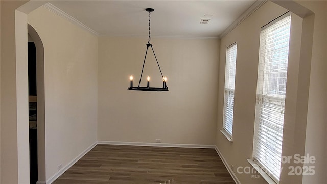 unfurnished dining area with dark wood-type flooring, an inviting chandelier, and ornamental molding