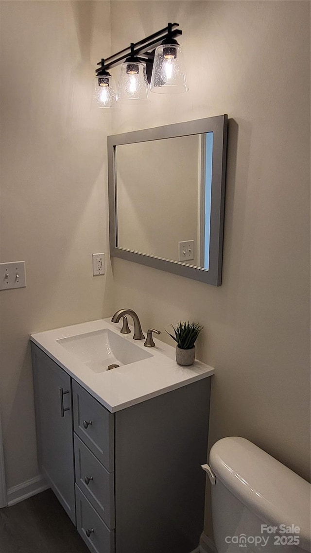 bathroom featuring toilet, vanity, and hardwood / wood-style flooring