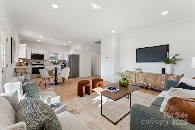 living room featuring light wood-type flooring and ornamental molding