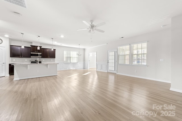 unfurnished living room featuring ceiling fan and light hardwood / wood-style floors