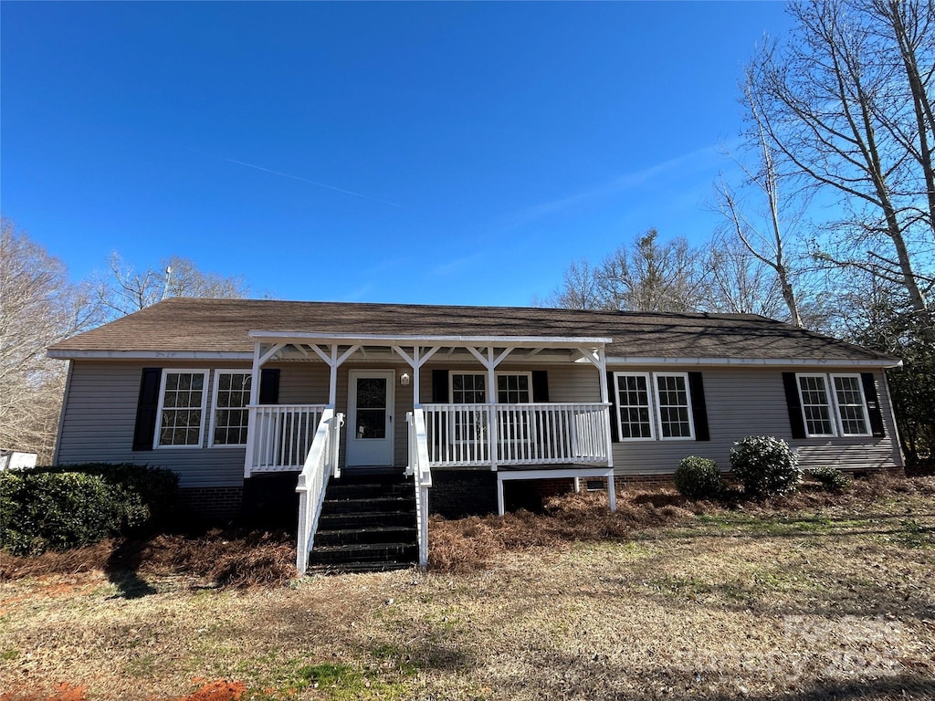 ranch-style house featuring a front lawn and a porch