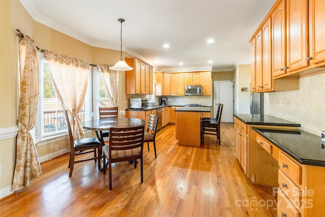 kitchen with appliances with stainless steel finishes, light wood-type flooring, hanging light fixtures, ornamental molding, and a center island