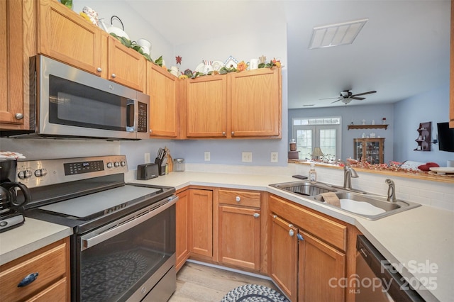 kitchen with ceiling fan, appliances with stainless steel finishes, light wood-type flooring, french doors, and sink