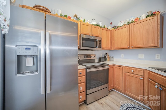 kitchen featuring appliances with stainless steel finishes and light hardwood / wood-style flooring