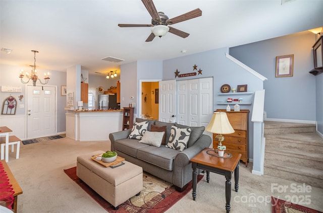 carpeted living room featuring ceiling fan with notable chandelier