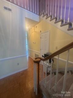 staircase featuring parquet floors