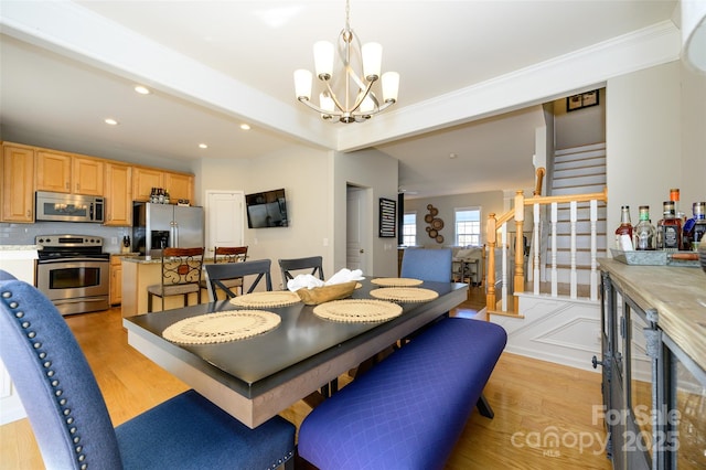 dining space featuring beamed ceiling, an inviting chandelier, and light hardwood / wood-style flooring