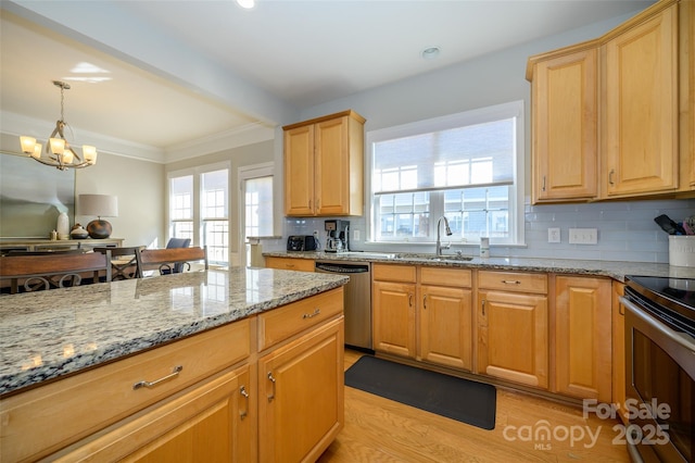 kitchen with decorative light fixtures, backsplash, sink, appliances with stainless steel finishes, and light stone counters