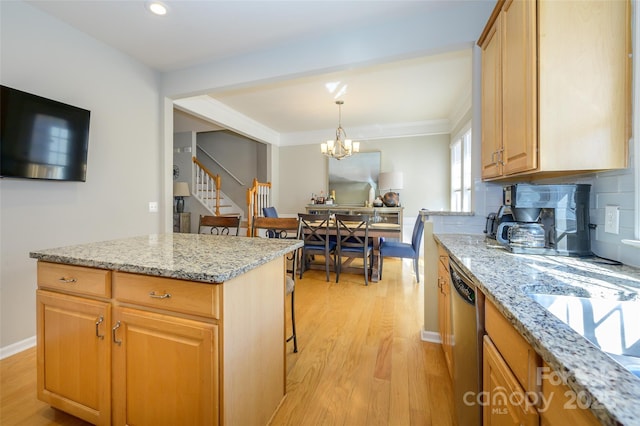 kitchen featuring backsplash, a notable chandelier, light stone countertops, stainless steel dishwasher, and light hardwood / wood-style flooring