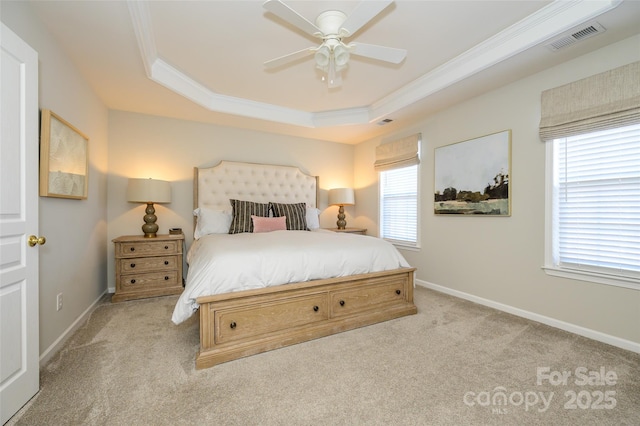 bedroom with ceiling fan, multiple windows, and a tray ceiling