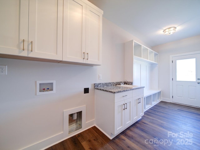 washroom with dark hardwood / wood-style floors, sink, hookup for a washing machine, hookup for an electric dryer, and cabinets