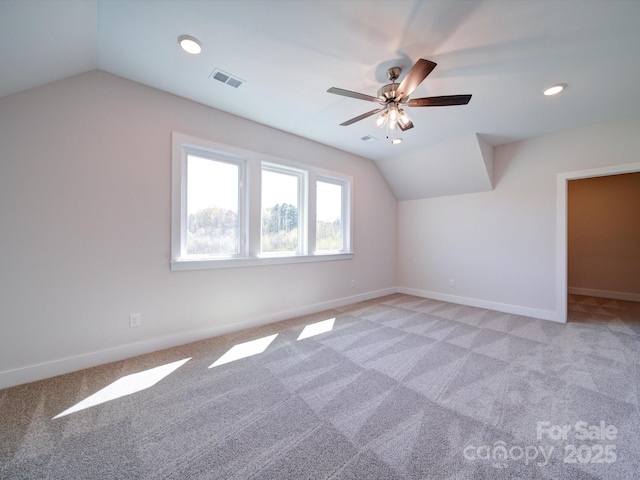 additional living space featuring ceiling fan, light colored carpet, and vaulted ceiling