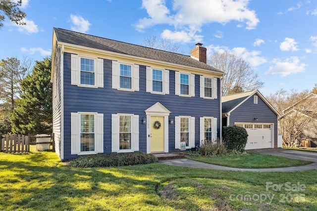 colonial inspired home with a front yard and a garage