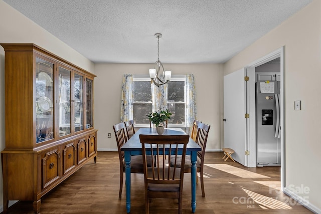 dining area with a textured ceiling, a chandelier, and dark hardwood / wood-style floors