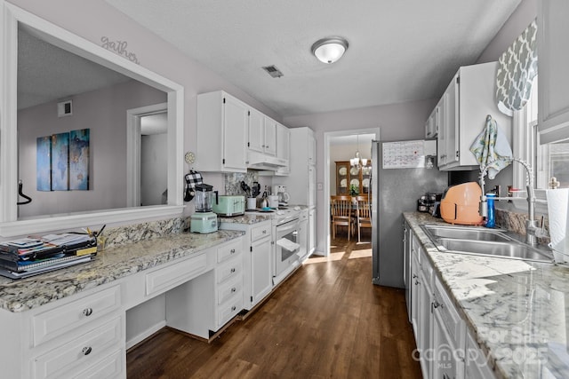 kitchen with stainless steel fridge, sink, white cabinetry, and a textured ceiling