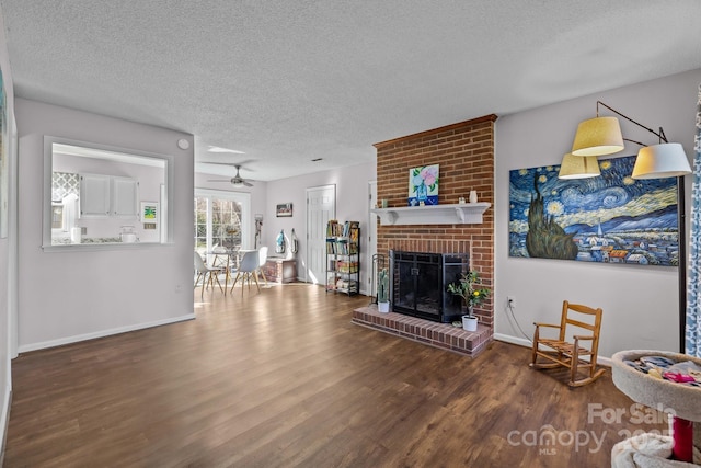 living room with ceiling fan, a fireplace, a textured ceiling, and hardwood / wood-style flooring