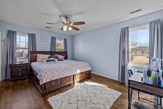 bedroom with a textured ceiling, ceiling fan, and dark hardwood / wood-style floors