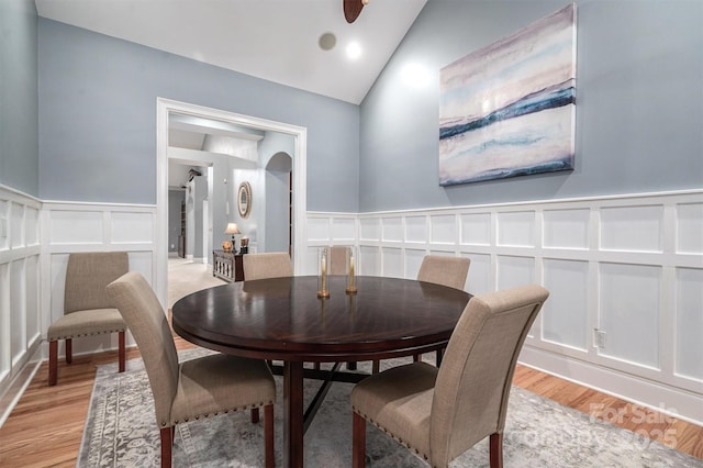 dining room with light wood-type flooring and vaulted ceiling