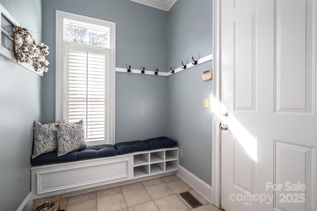 mudroom with ornamental molding and light tile patterned flooring