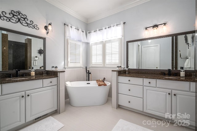 bathroom with a bathtub, vanity, tile walls, and ornamental molding