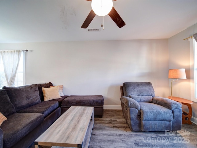 living room featuring ceiling fan and dark wood-type flooring