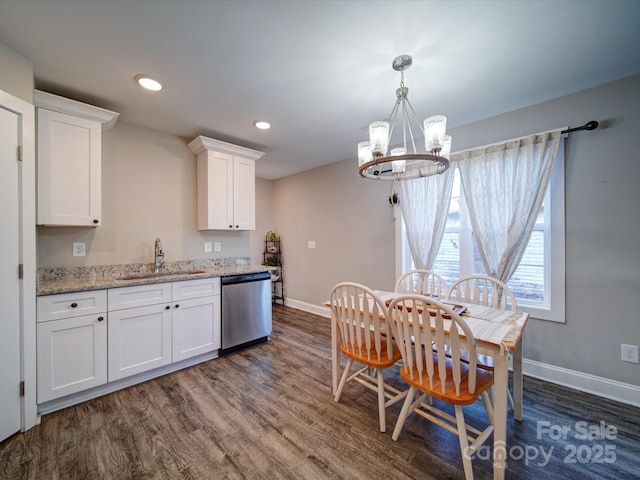 kitchen featuring light stone countertops, a chandelier, stainless steel dishwasher, white cabinets, and sink