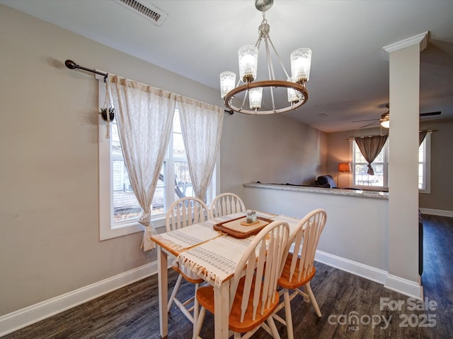 dining area with dark hardwood / wood-style flooring and ceiling fan with notable chandelier