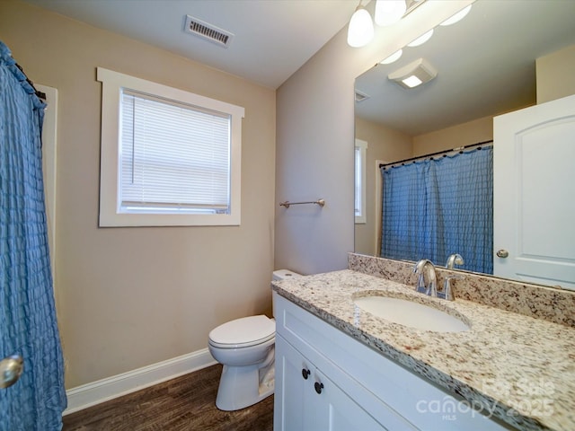 bathroom with hardwood / wood-style floors, toilet, and vanity