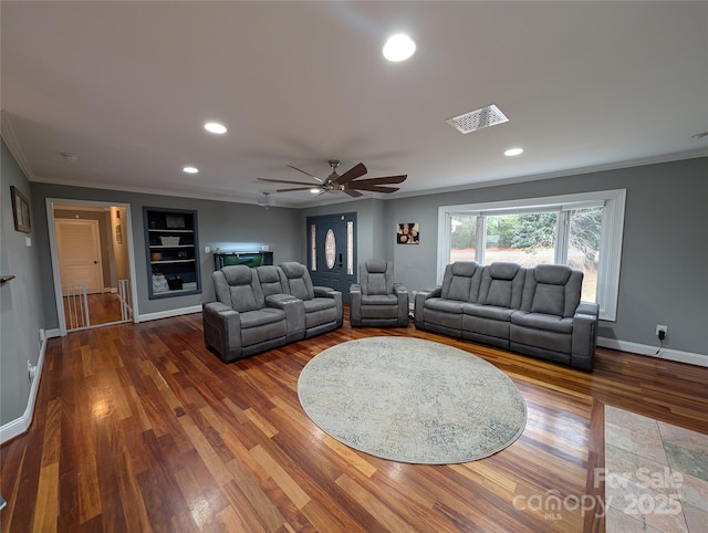 living room with ceiling fan, hardwood / wood-style floors, built in features, and crown molding