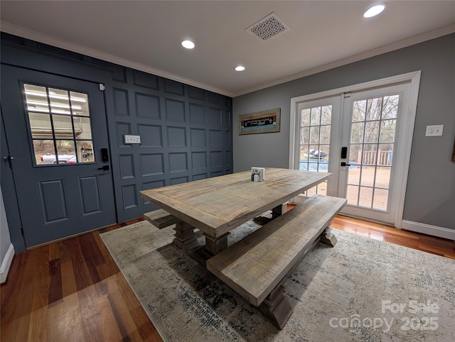 dining room featuring dark wood-type flooring, crown molding, and french doors