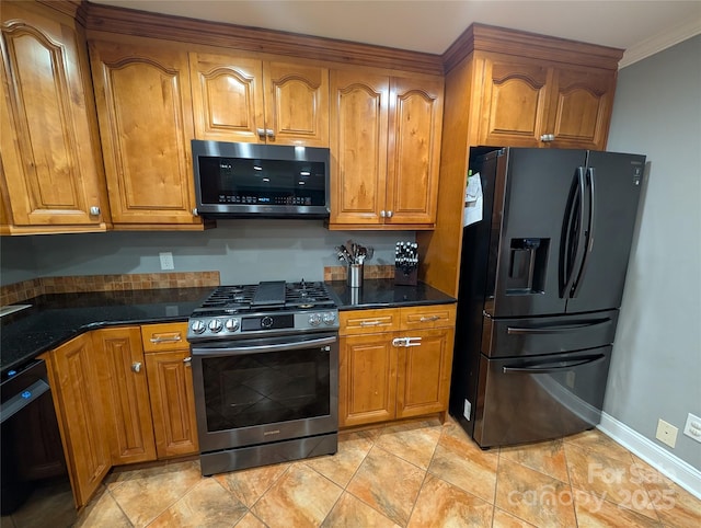 kitchen featuring ornamental molding, dark stone counters, and black appliances