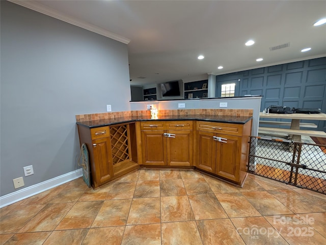 kitchen with crown molding and dark stone counters