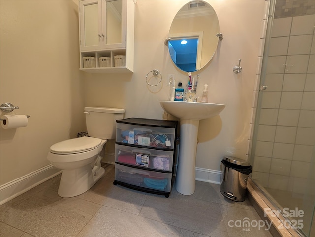 bathroom featuring toilet, an enclosed shower, and sink