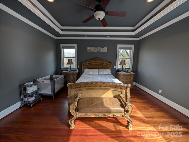 bedroom featuring ceiling fan, ornamental molding, wood-type flooring, and a raised ceiling