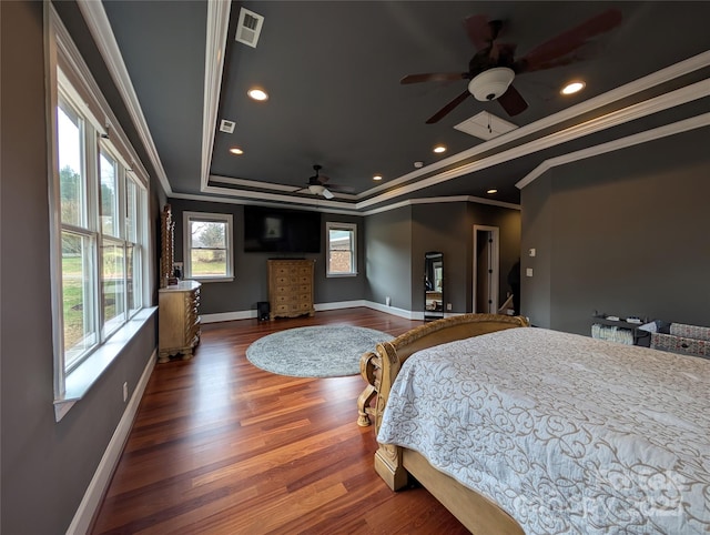 bedroom with ceiling fan, dark wood-type flooring, a tray ceiling, and ornamental molding