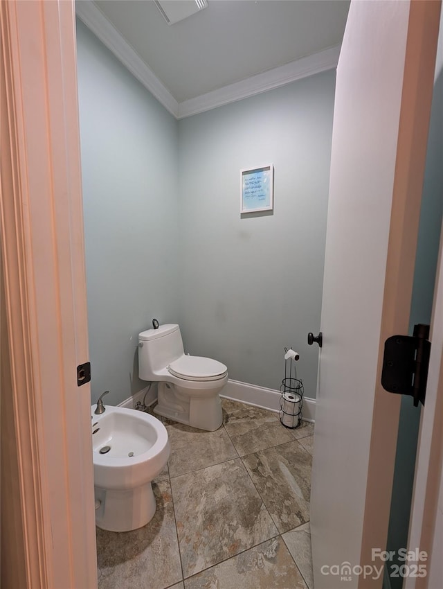 bathroom with toilet, a bidet, and crown molding