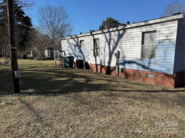 view of side of property featuring cooling unit and a lawn