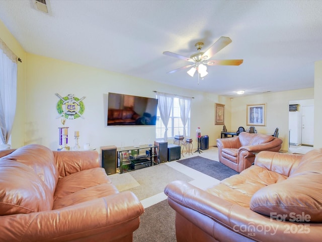 living room featuring ceiling fan, a textured ceiling, and carpet floors