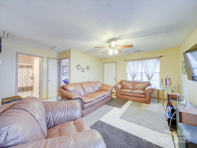 living room featuring ceiling fan, a textured ceiling, and light carpet